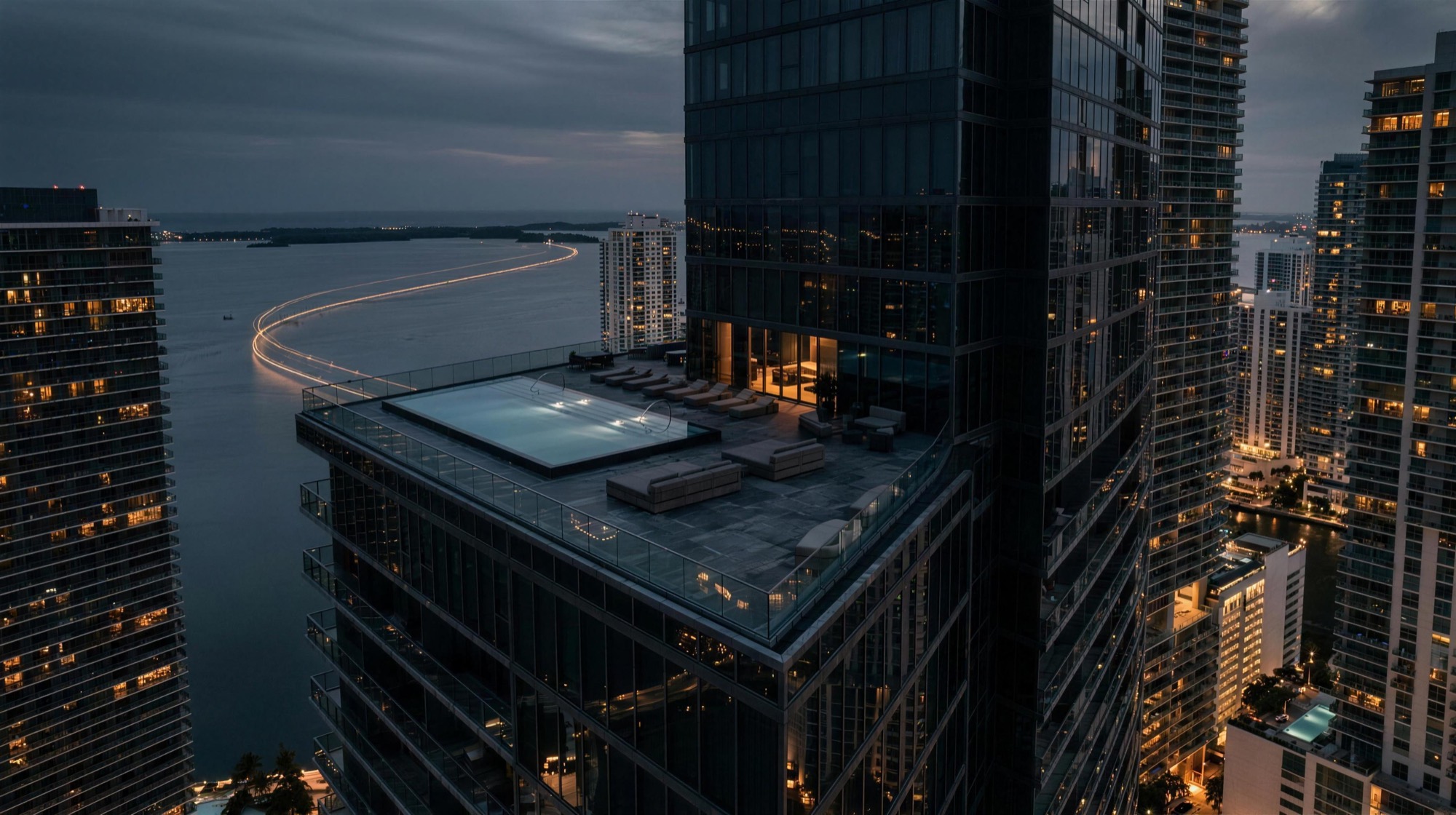 Penthouse rooftop pool at blue hour high above Biscayne Bay